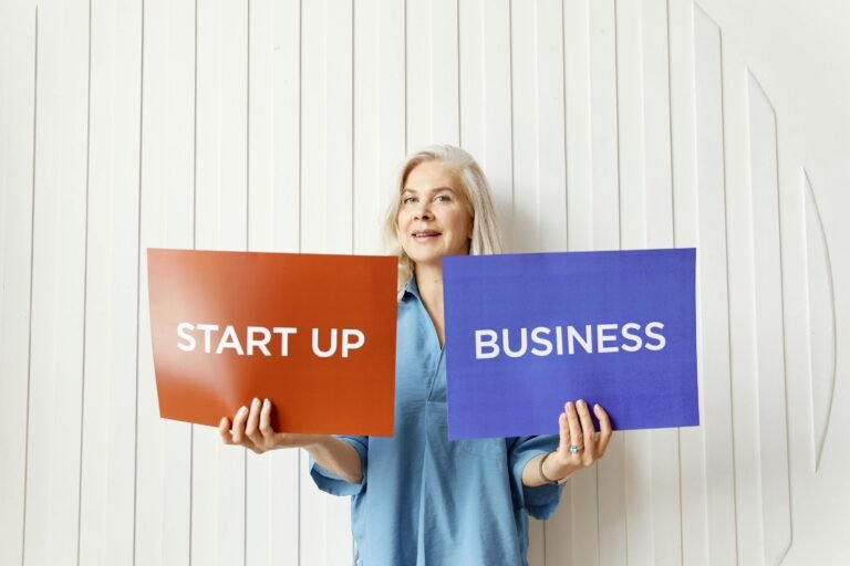 Best Remote Jobs for Ex-Admins, Ex-Marketers, and Career Changers in 2025 Elderly woman holding startup and business signs indoors against white background.