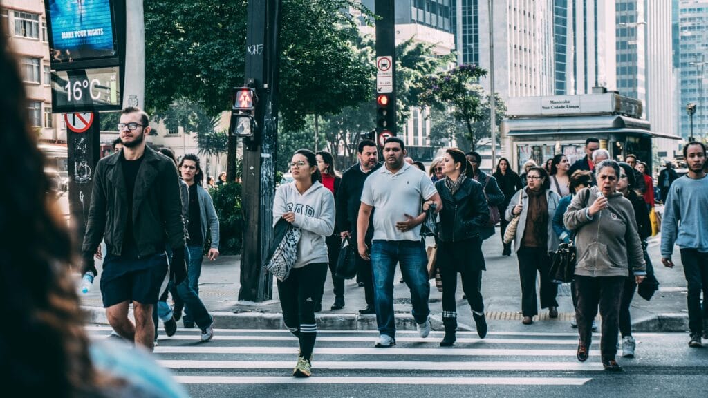 pexels-photo-109919-109919 A diverse group of people crossing a street in a bustling city setting with skyscrapers.