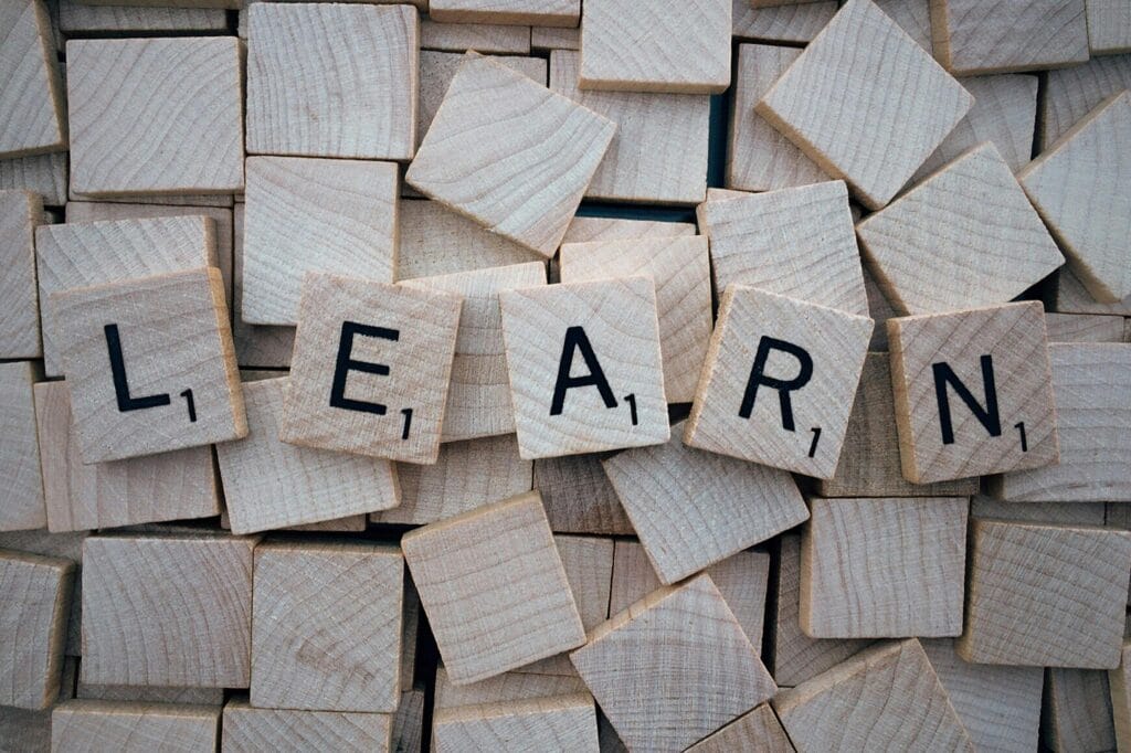 pexels-photo-247819-247819 Wooden letter tiles arranged to spell 'learn' on a background of scattered tiles.