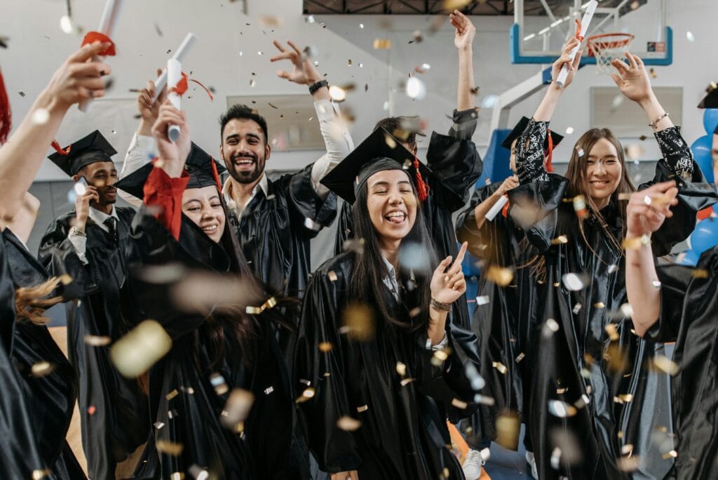 pexels-photo-7944235-7944235 Group of diverse students celebrating graduation with confetti indoors.